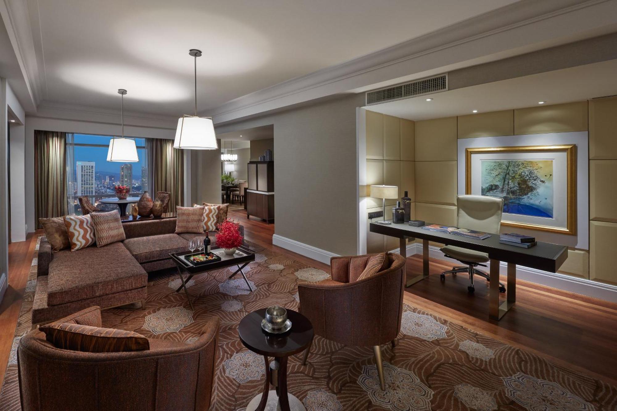 מלון Mandarin Oriental, קואלה לומפור מראה חיצוני תמונה The photo shows a well-furnished hotel suite or living area. It features a cozy seating arrangement with a large sofa and two armchairs. There is a coffee table in the center, along with decorative elements like a small flower arrangement. The room i