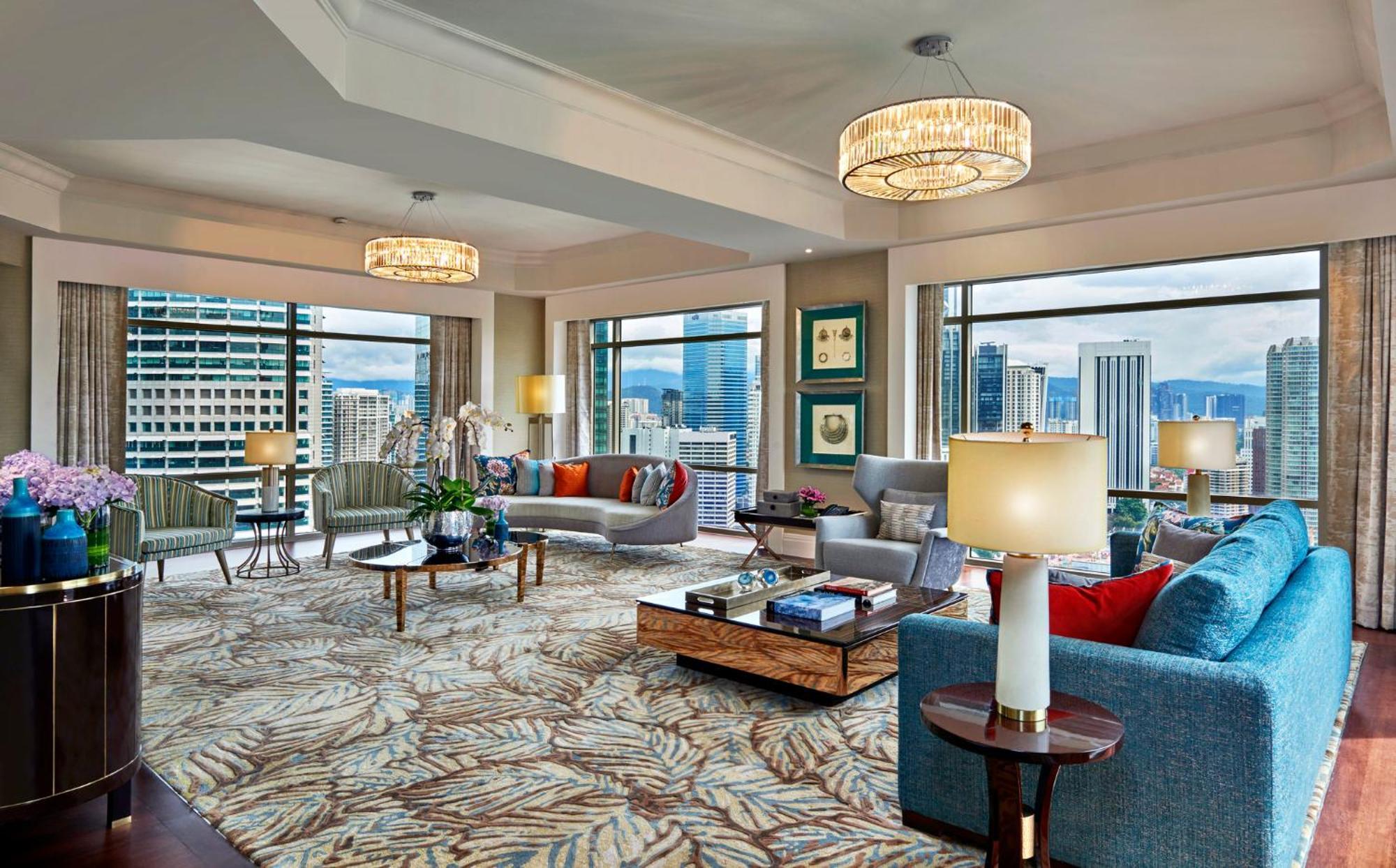 מלון Mandarin Oriental, קואלה לומפור מראה חיצוני תמונה The photo depicts a luxurious living space, likely in a high-rise building. The room features large windows that provide a panoramic view of a city skyline. The interior is elegantly designed with modern furniture, including a mix of sofas in differe