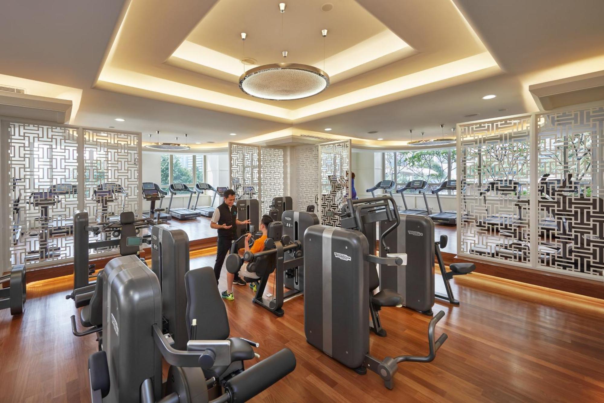מלון Mandarin Oriental, קואלה לומפור מראה חיצוני תמונה The photo shows a modern gym environment. It features several exercise machines, including strength training equipment and treadmills. The space has a well-lit and spacious design, with wooden flooring and contemporary lighting fixtures. Large window