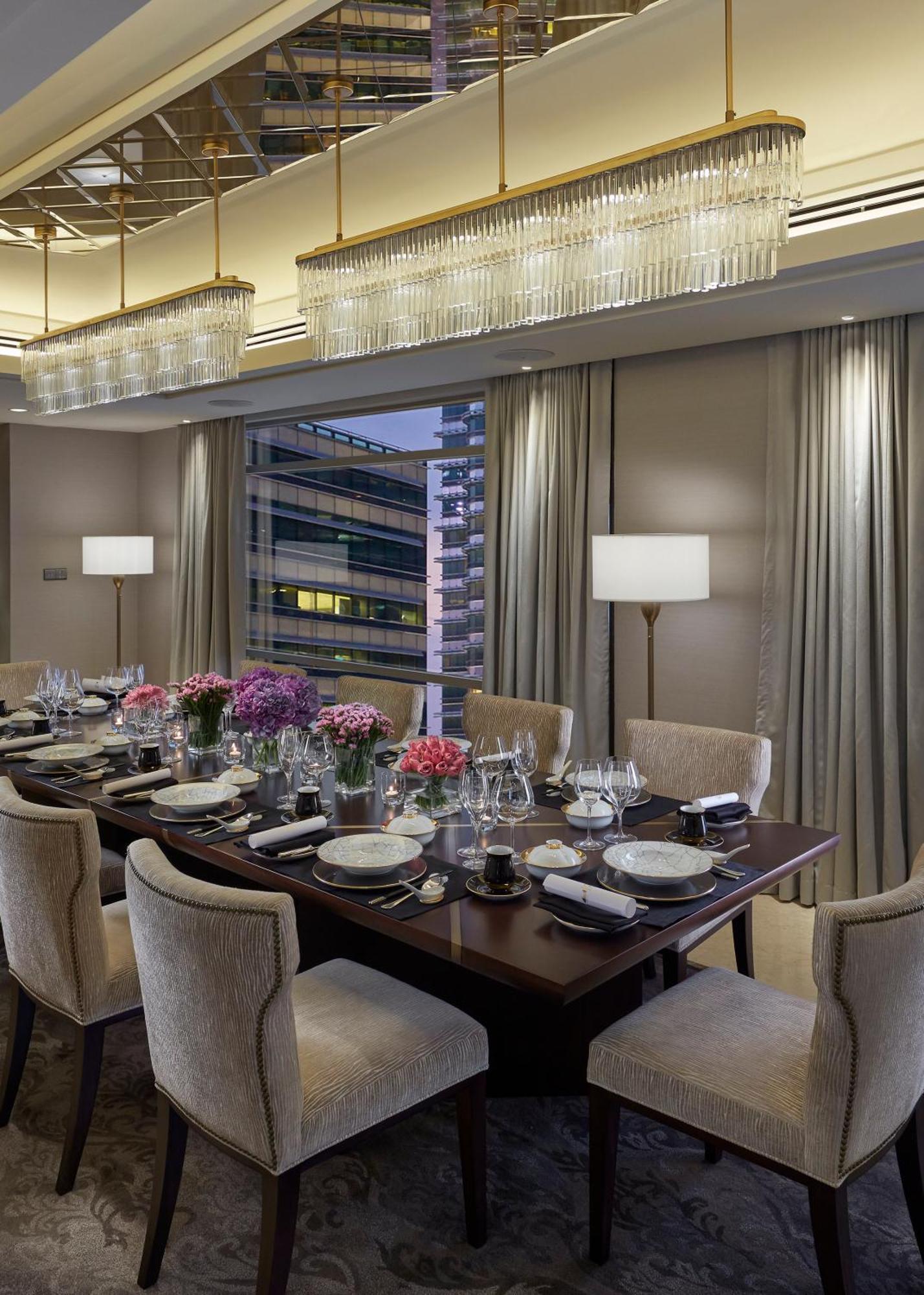 מלון Mandarin Oriental, קואלה לומפור מראה חיצוני תמונה The photo shows an elegantly set dining table in a modern restaurant or private dining room. The table is adorned with beautiful flower arrangements, including pink and purple blooms. Each place setting includes fine dining plates, glassware, and cut