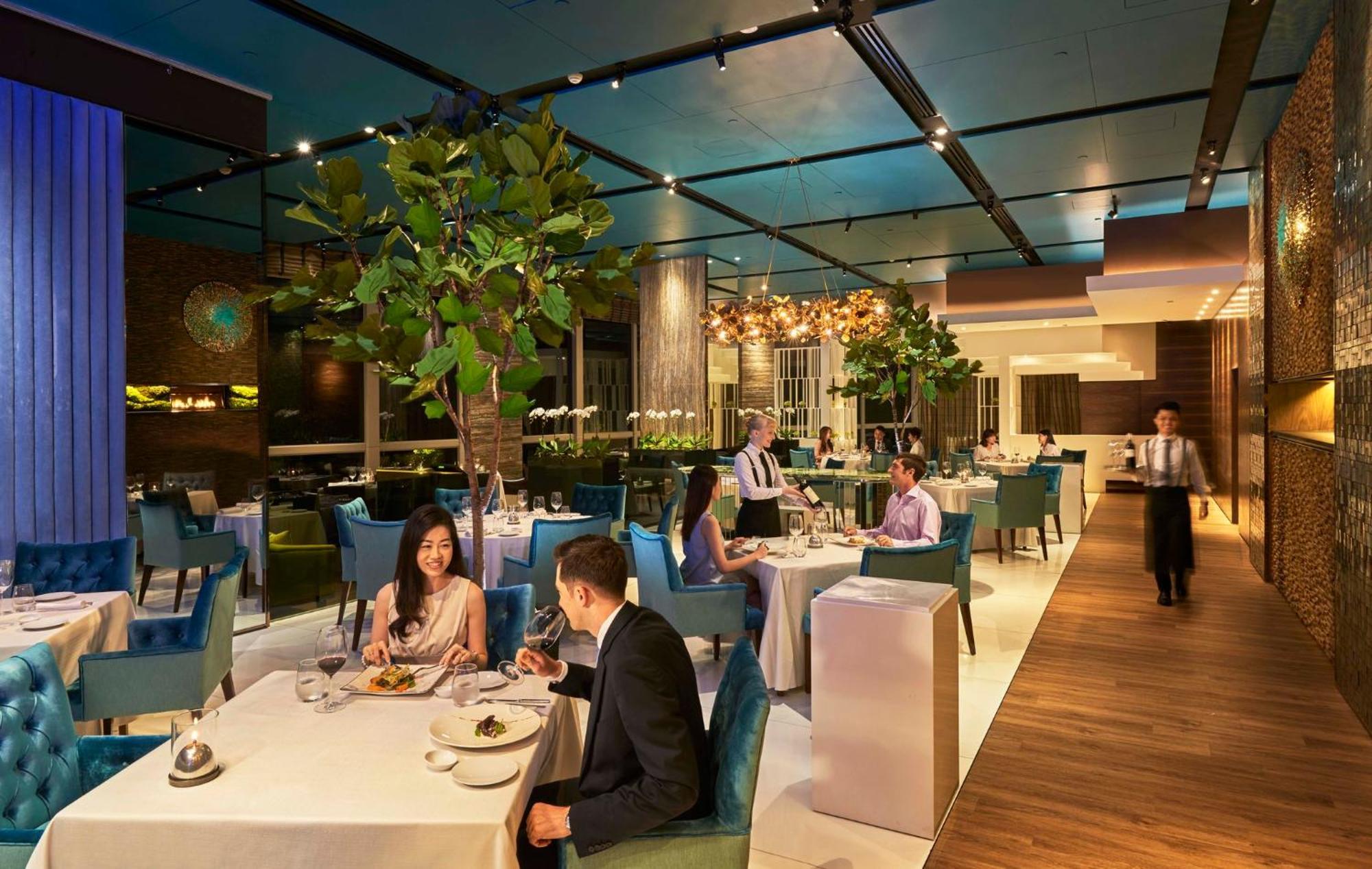 מלון Mandarin Oriental, קואלה לומפור מראה חיצוני תמונה The photo depicts a stylish and modern restaurant interior. It features elegant tables with white tablecloths, some adorned with candles or decorative items. Patrons are seated at the tables, engaged in conversation and enjoying their meals. The deco