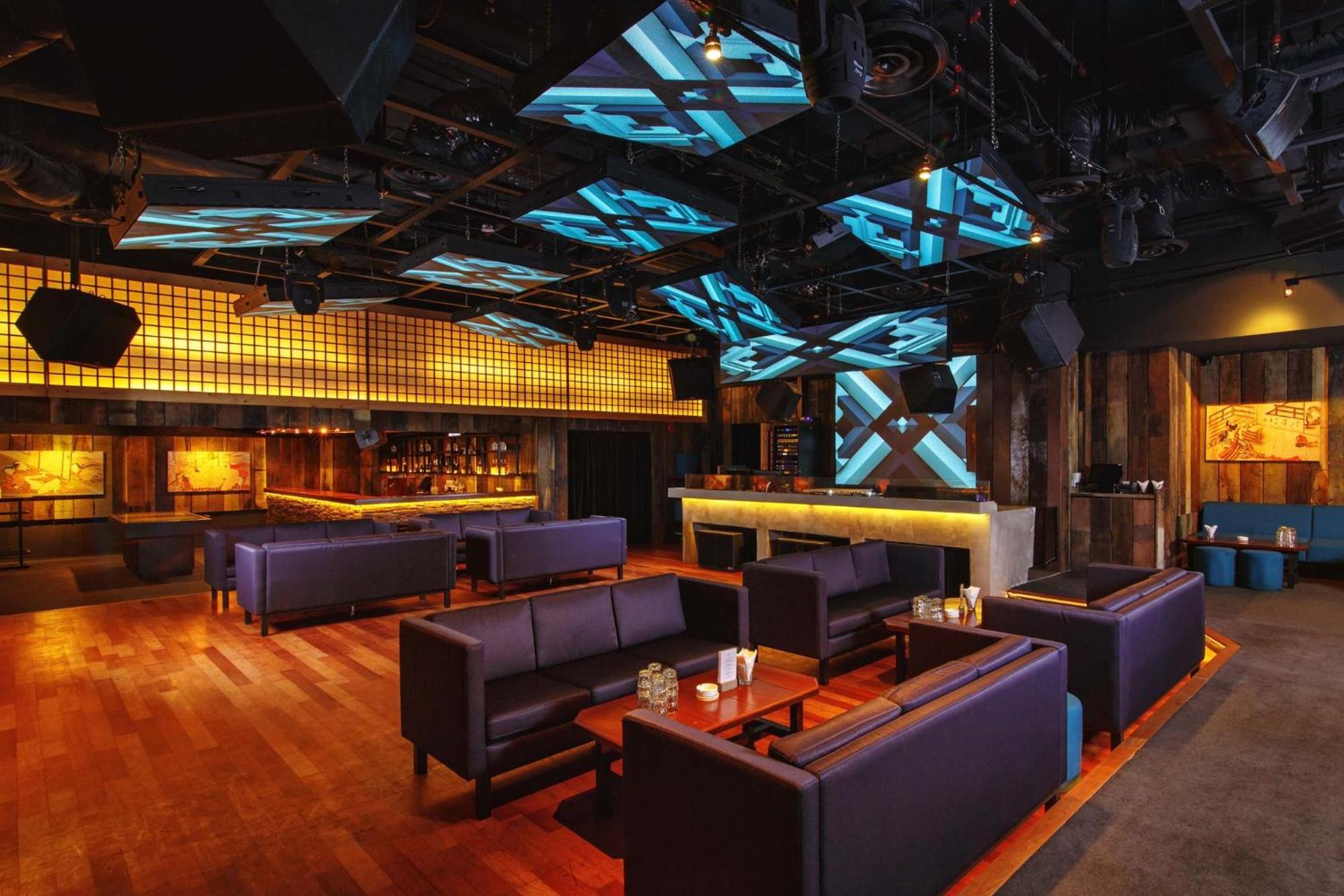 מלון Mandarin Oriental, קואלה לומפור מראה חיצוני תמונה The photo shows a modern and stylish interior of a lounge or bar. The space features a wooden floor and is furnished with dark purple couches arranged around low tables. In the background, there is a bar area illuminated with warm lighting, and the b