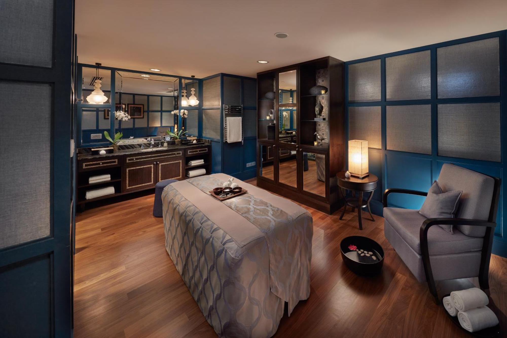 מלון Mandarin Oriental, קואלה לומפור מראה חיצוני תמונה The photo shows a well-designed spa or treatment room. The space features a massage table adorned with a soothing gray cover. On the table, there are a few items, possibly for decoration or treatment, like small bowls or stones. 

The room's walls ar
